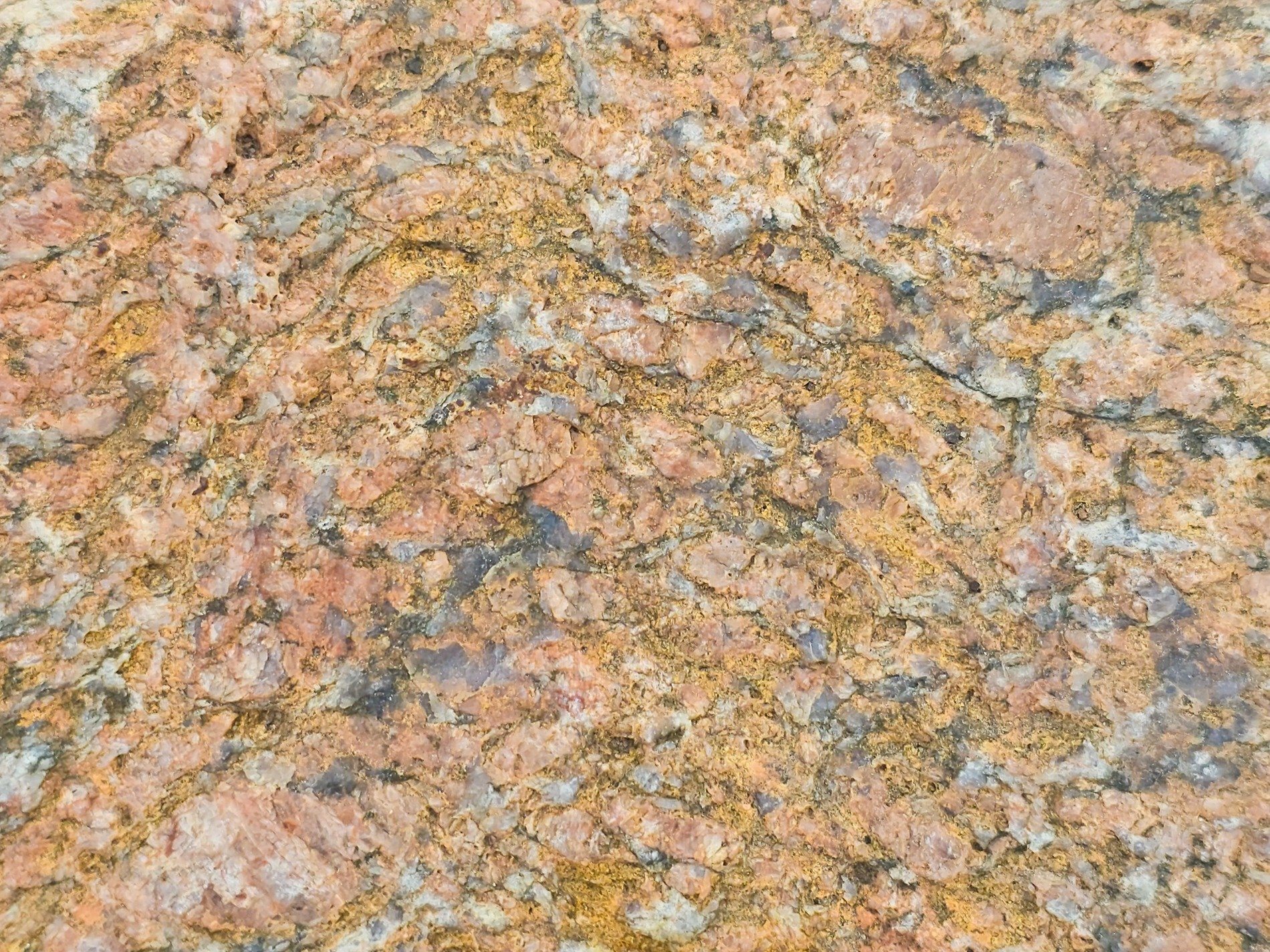 Pale pink minerals, granite veins carve through the rock, ancient stone persists