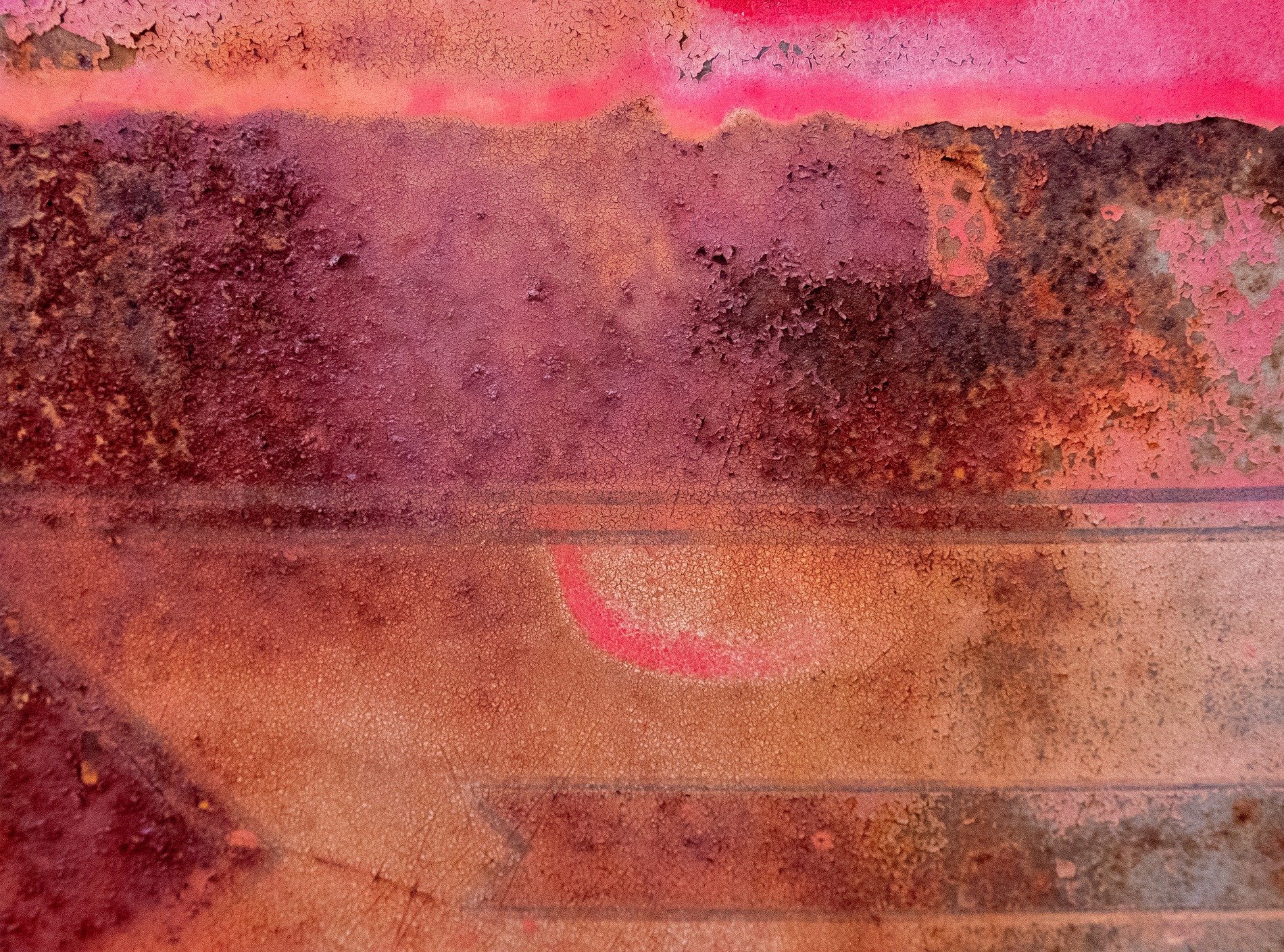Pink layers fade down, rusty edges meet the light, grit marks the metal
