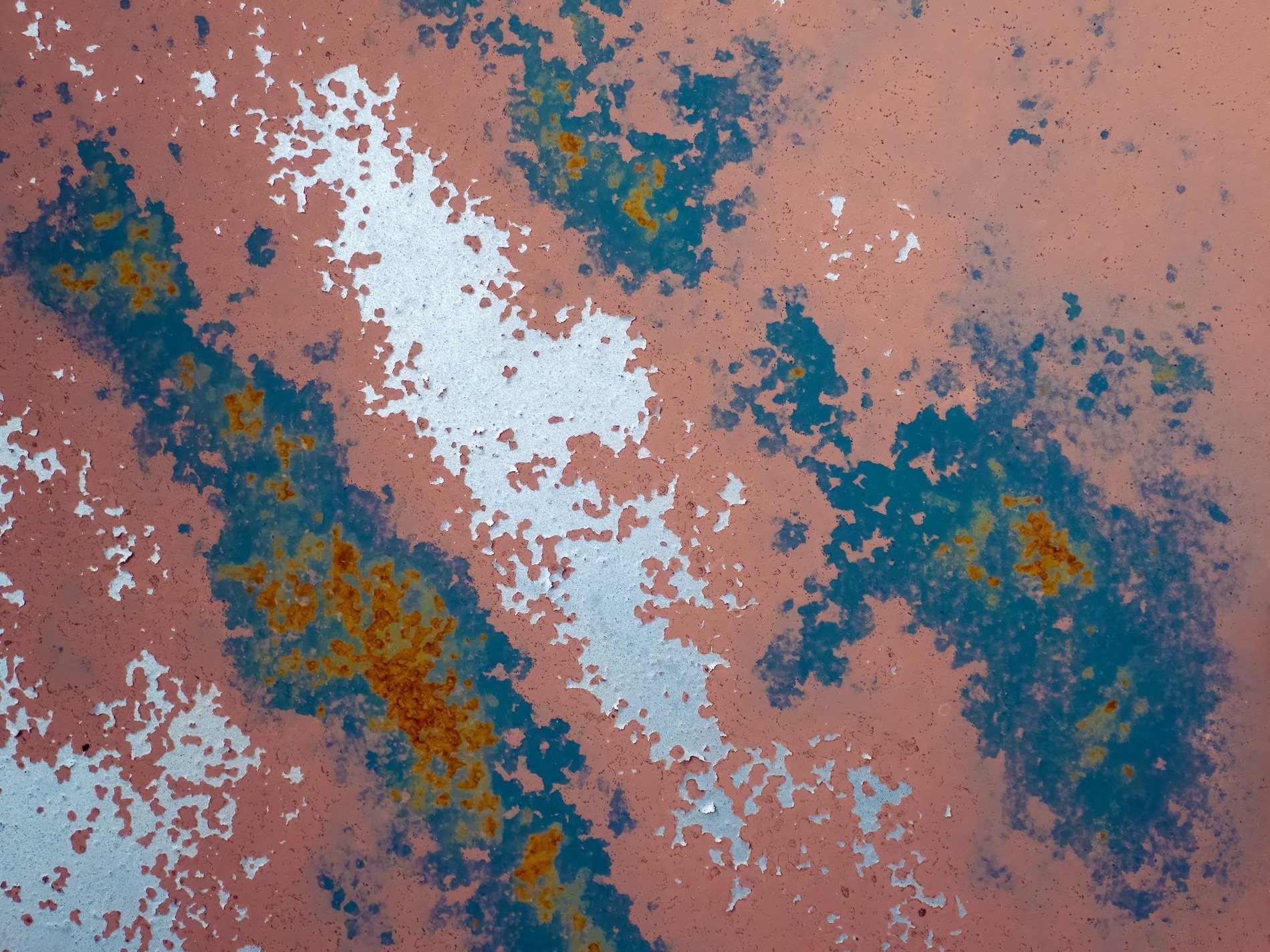 Pink paint peels away, blue and rust bloom on the steel, weathered metal fades