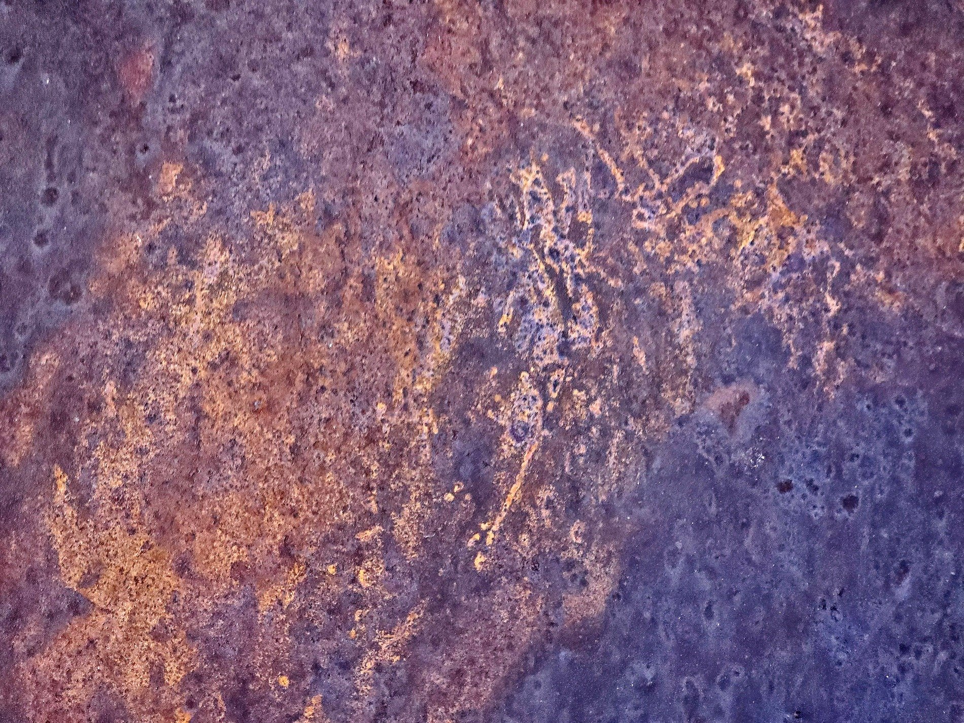 Purple shadows flow thick, heavy pits mark the surface, grit claims the stone