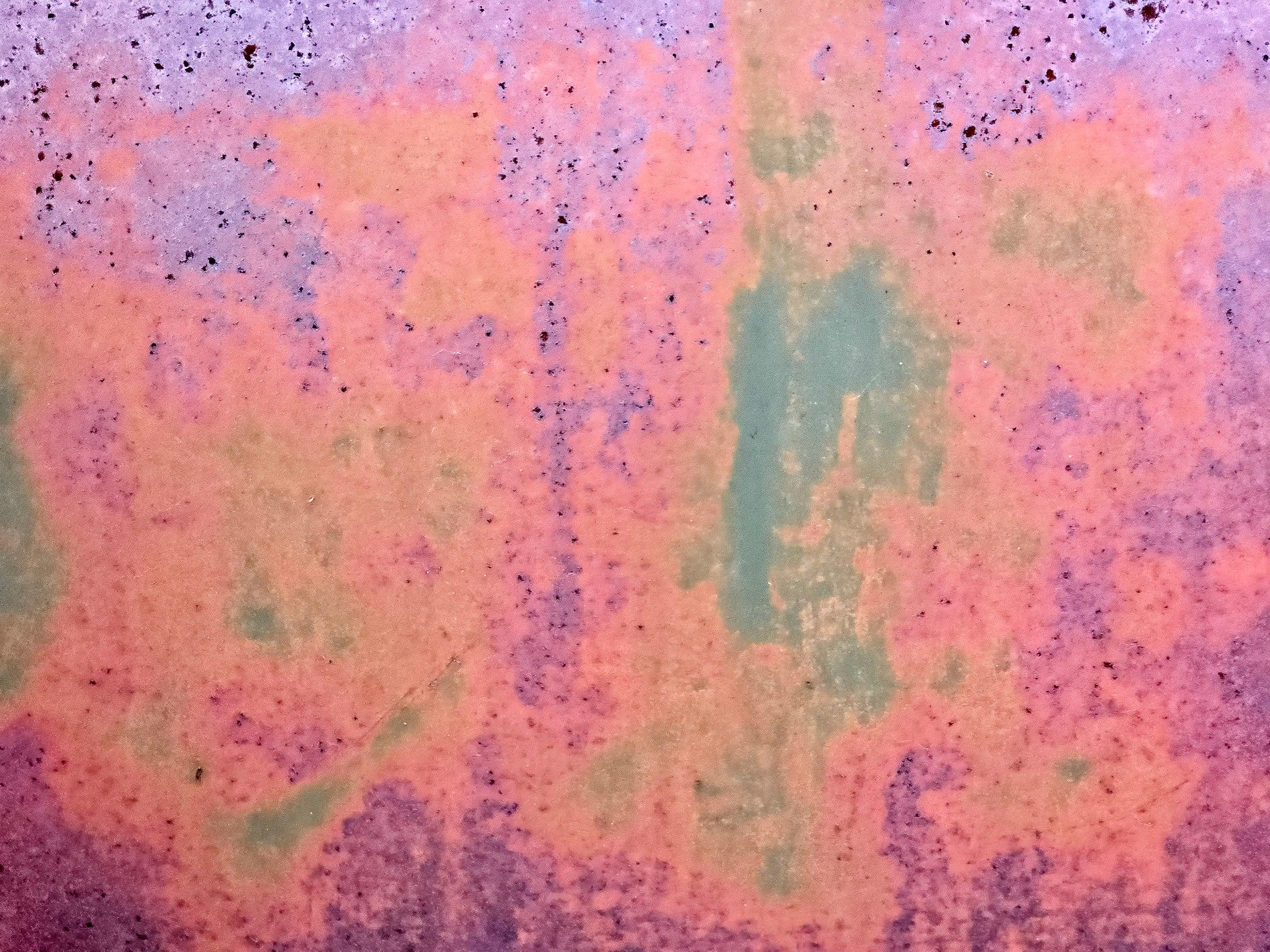 Purple paint wears thin, orange rust blooms on the steel, teal hides in the depths