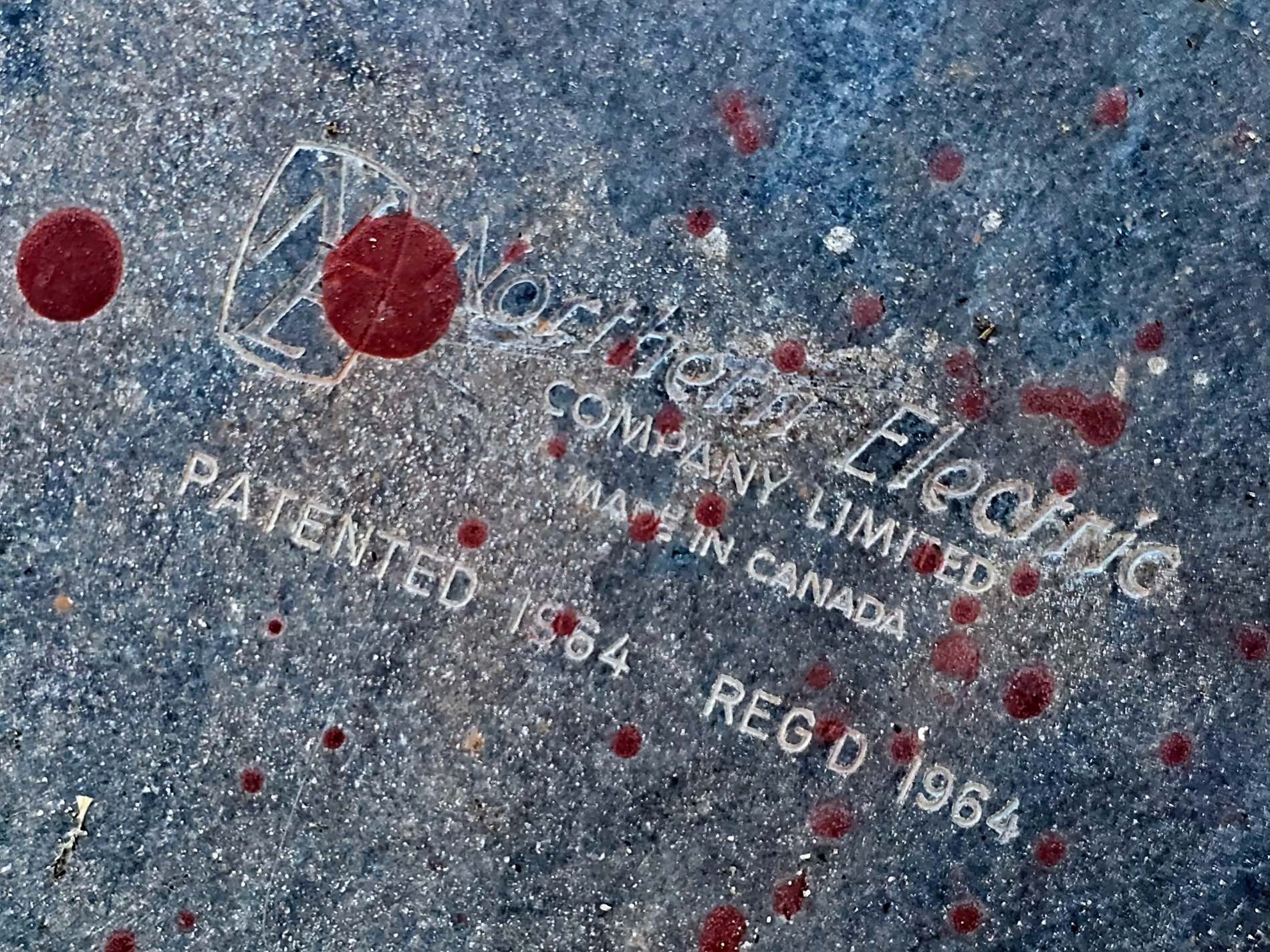 Raised type on cold blue, scarlet paint spatters the steel, sixty four remains