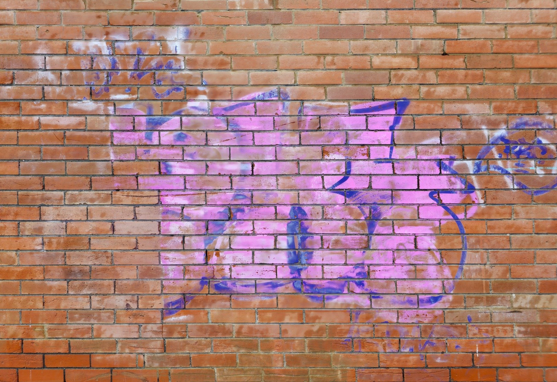 Red bricks line the path, pink paint ghosts across the clay, blue lines trace the edge