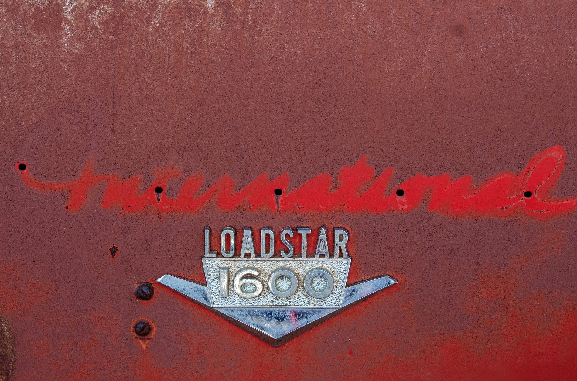 Red fields hold the badge, chrome wings meet the heavy rust, time claims the metal