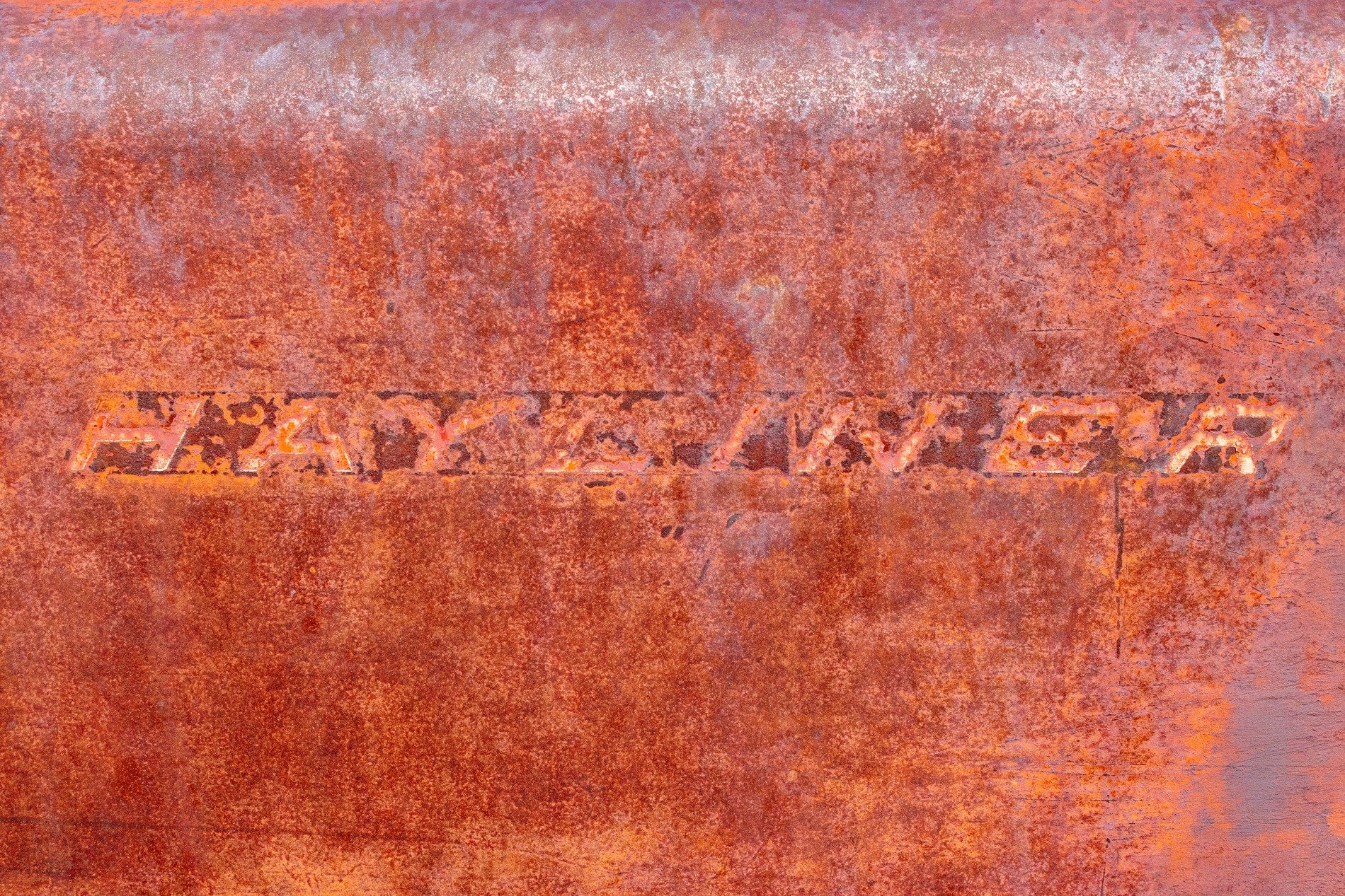 Red fields hold the name, heavy grit claims the script, time marks the metal