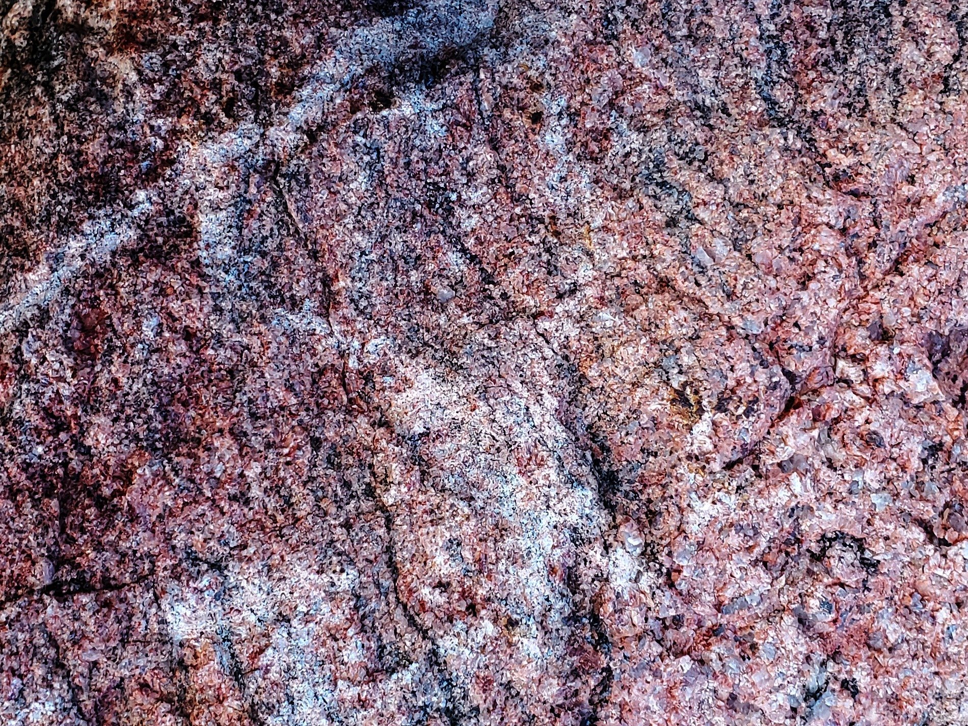 Red fields meet the grey, mottled grain holds the surface, grit marks the finish