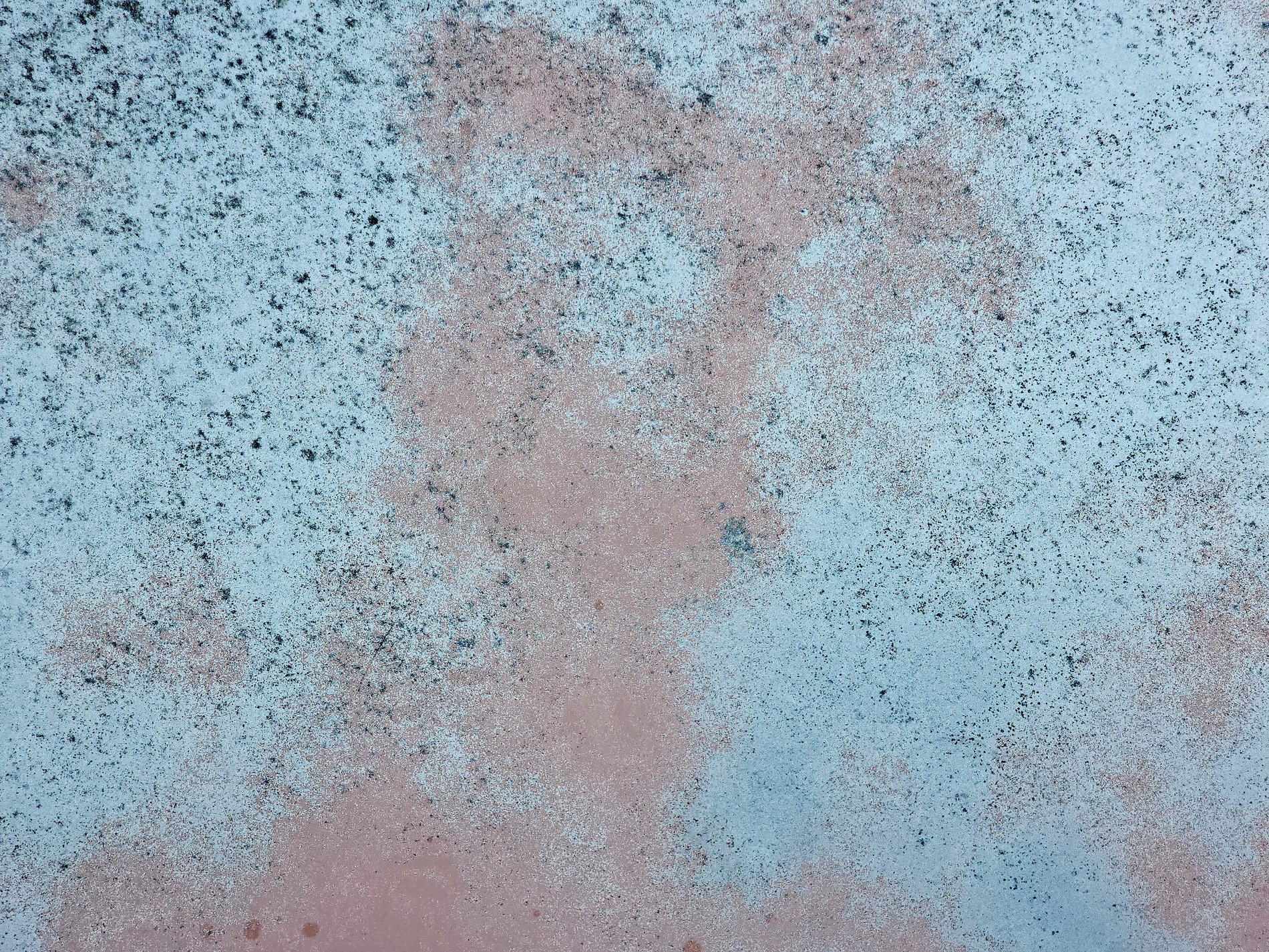 Pale blue fades away, pink foundations are revealed, dark specks mark the years