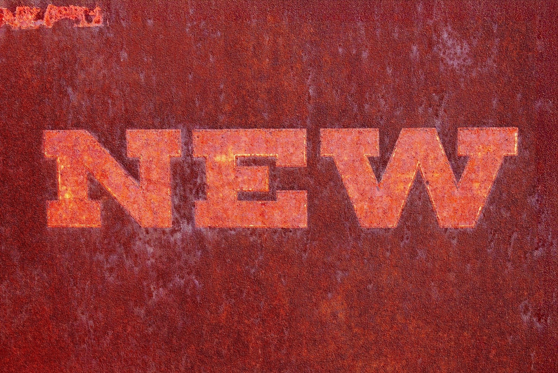 Red fields meet the rust, "NEW" script marks the heavy skin, time marks the metal