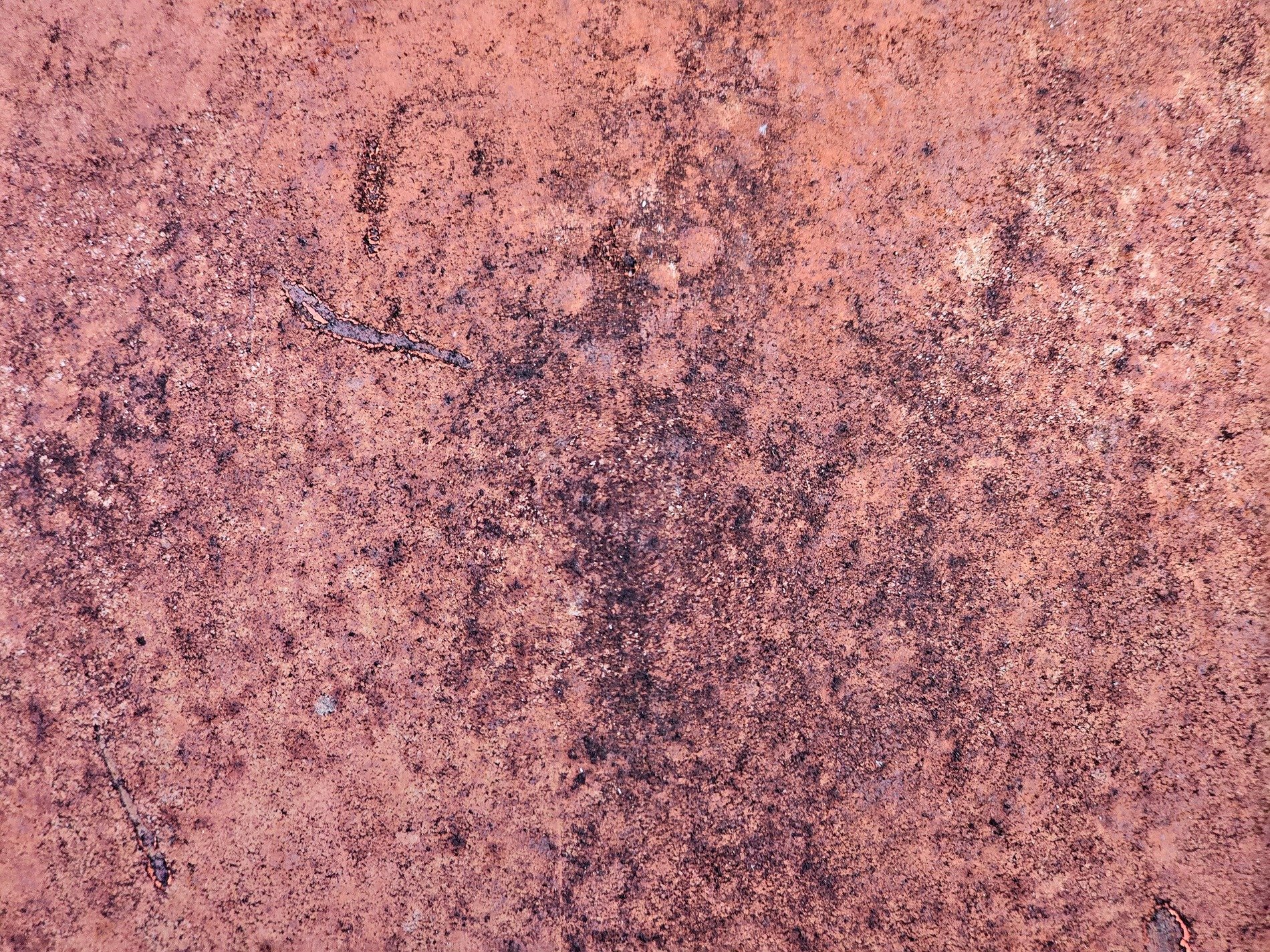 Red oxidation, mottled surface scarred by time, iron starts to fade
