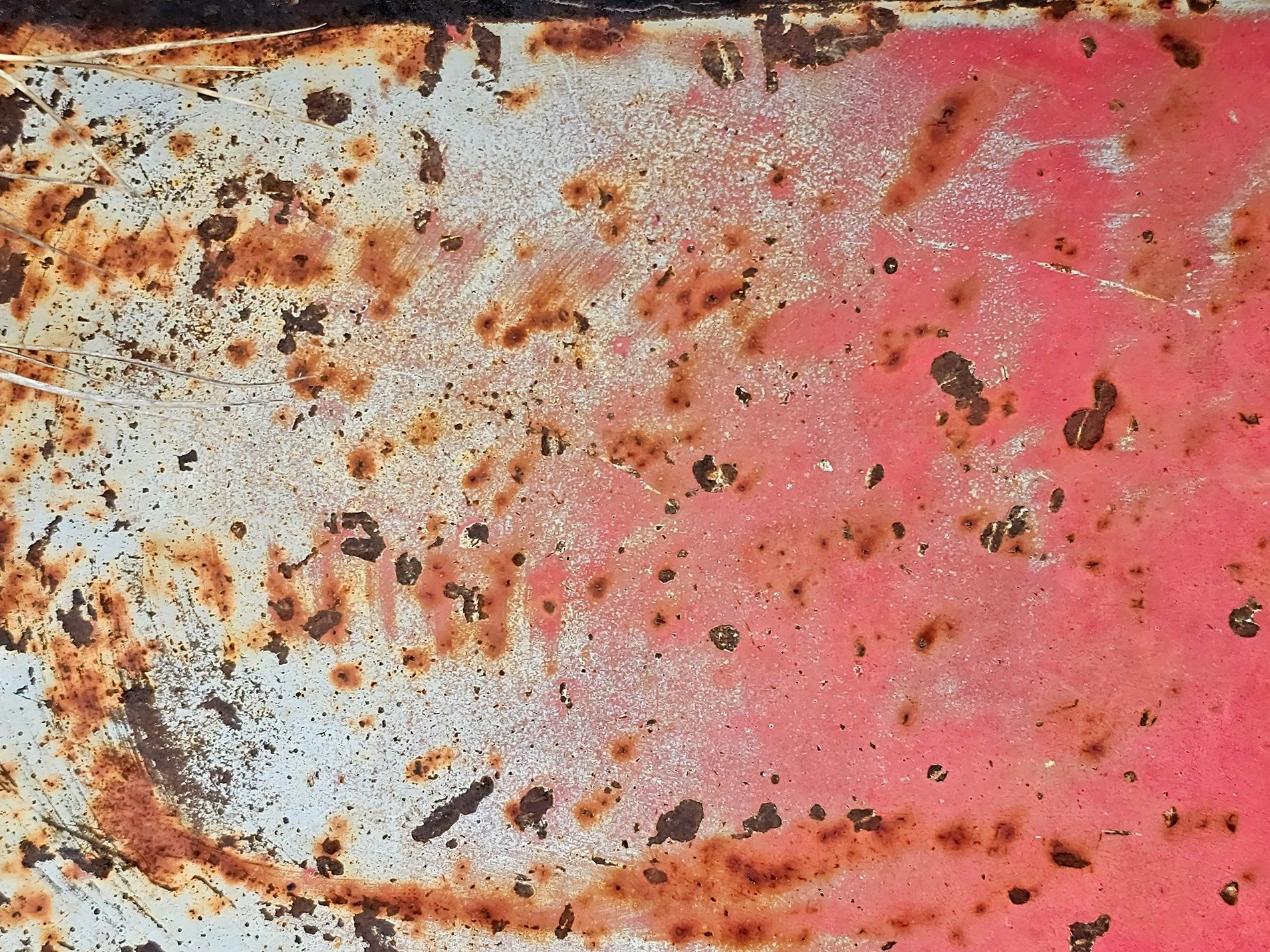 Red paint flakes away, iron yields to orange rust, surface turns to dust