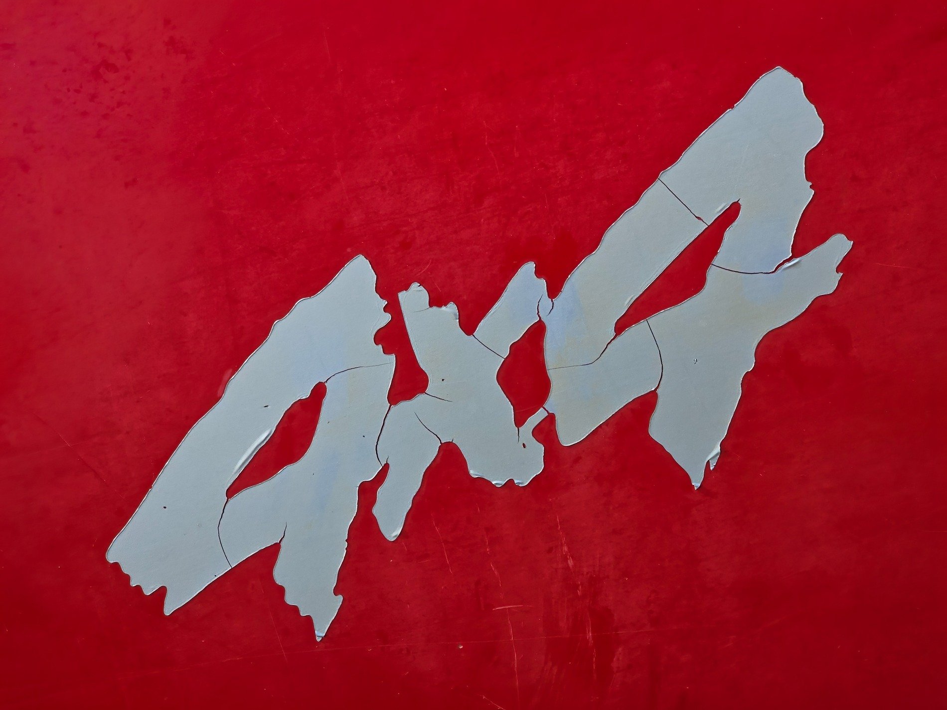 Red paint starts to fade, silver decal cracks and peels, rugged signs decay