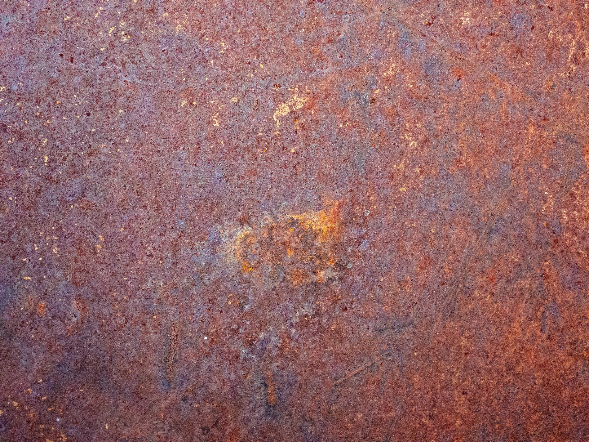 Red rust coats the steel, iron blooms in mottled brown, time eats through the core