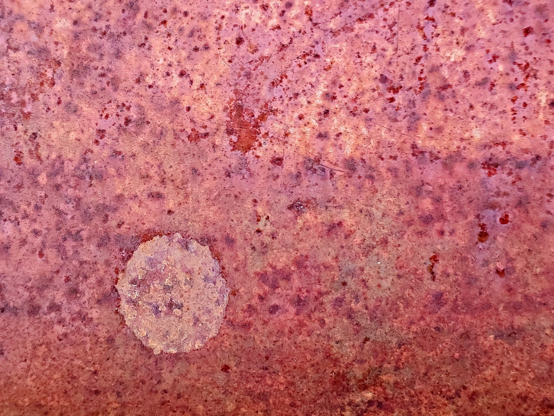 Red rust eats the steel, circular stain marks the spot, time decays the plate