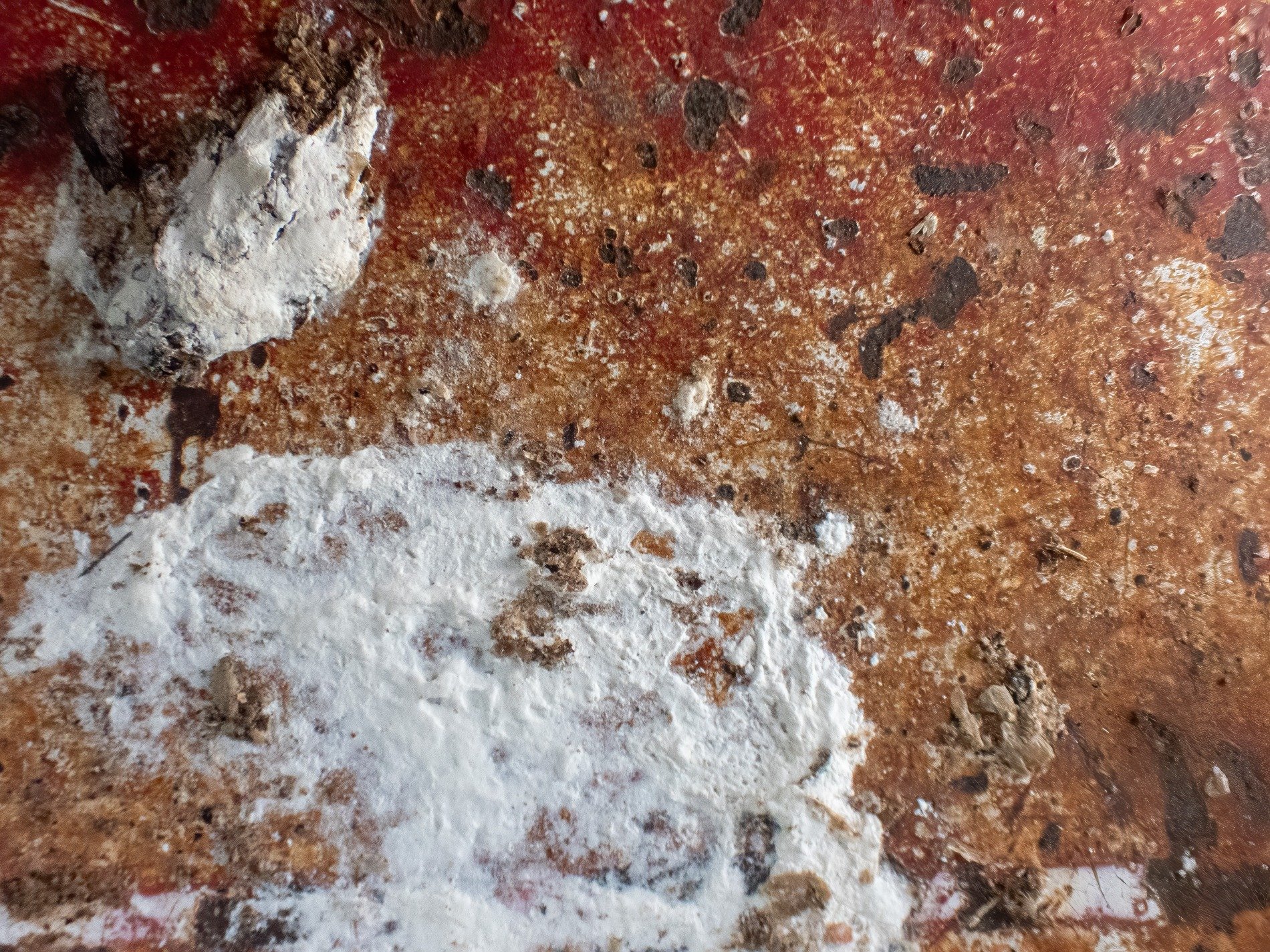 Red skin has white trails, jagged paths trace the heavy, light carves the metal