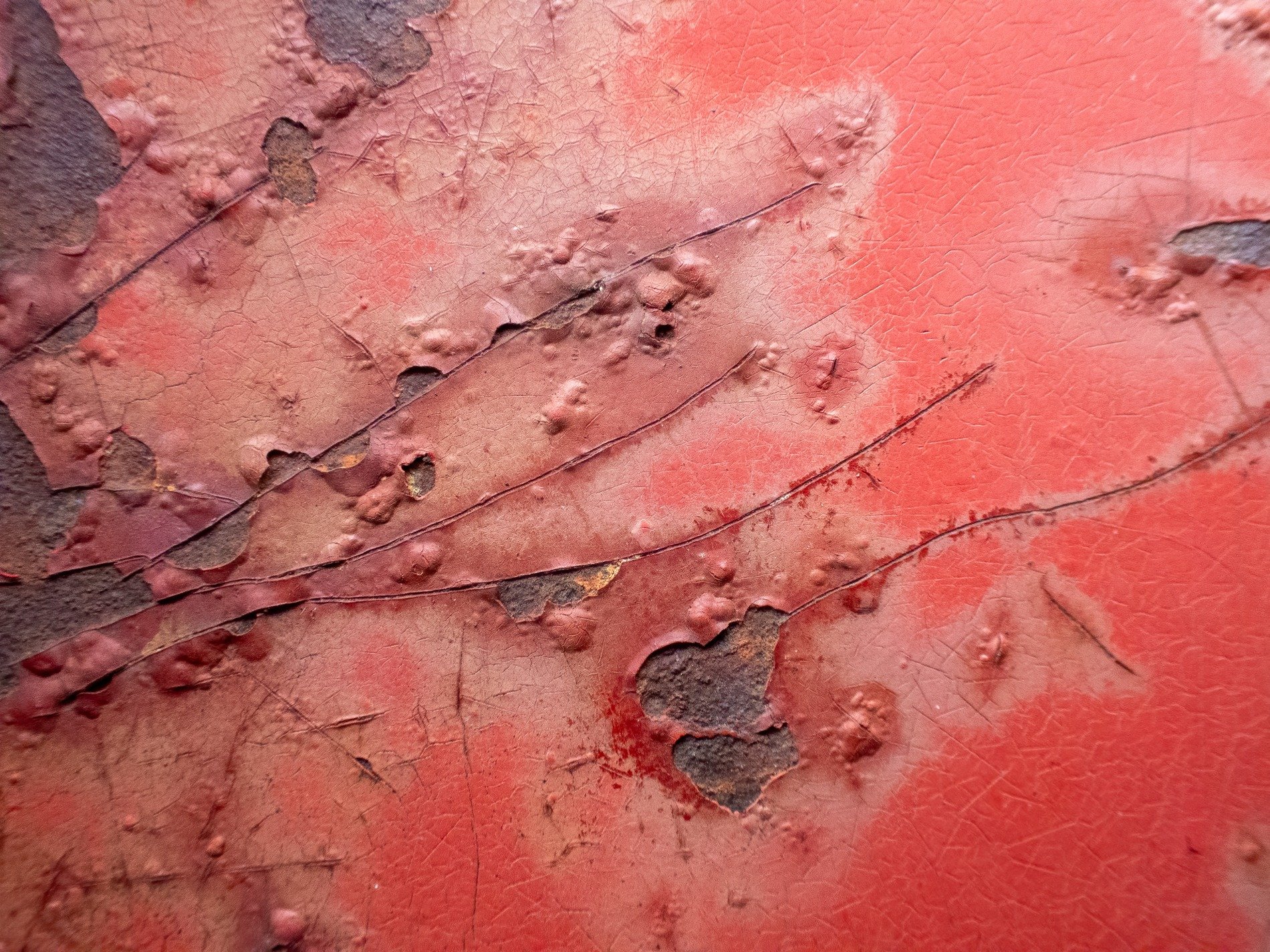 Red skin holds bubbles, jagged scars trace the heavy, grit marks the finish