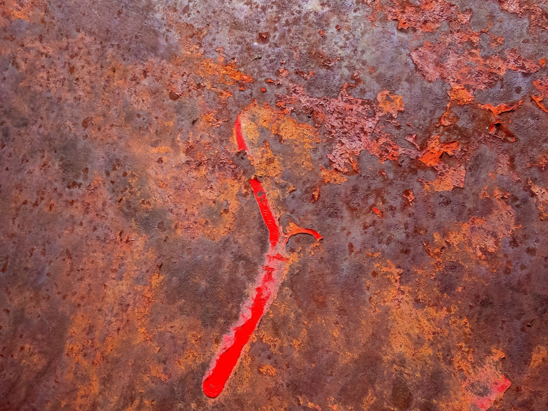 Red streaks haunt the field, dark grit claims the heavy surface, time marks the metal