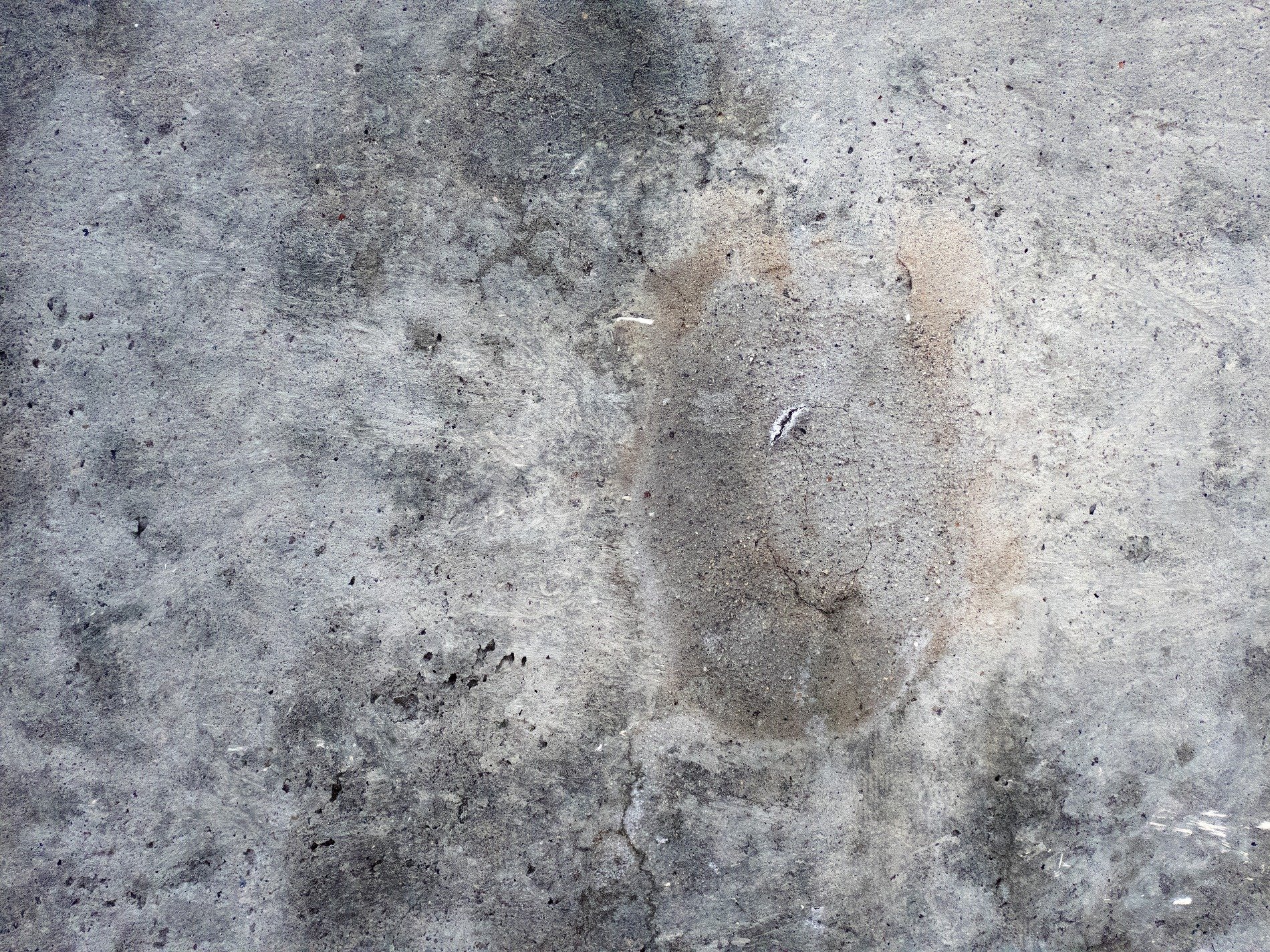 Rough slab worn by time, shadows dance on pitted grey, ancient stains remain