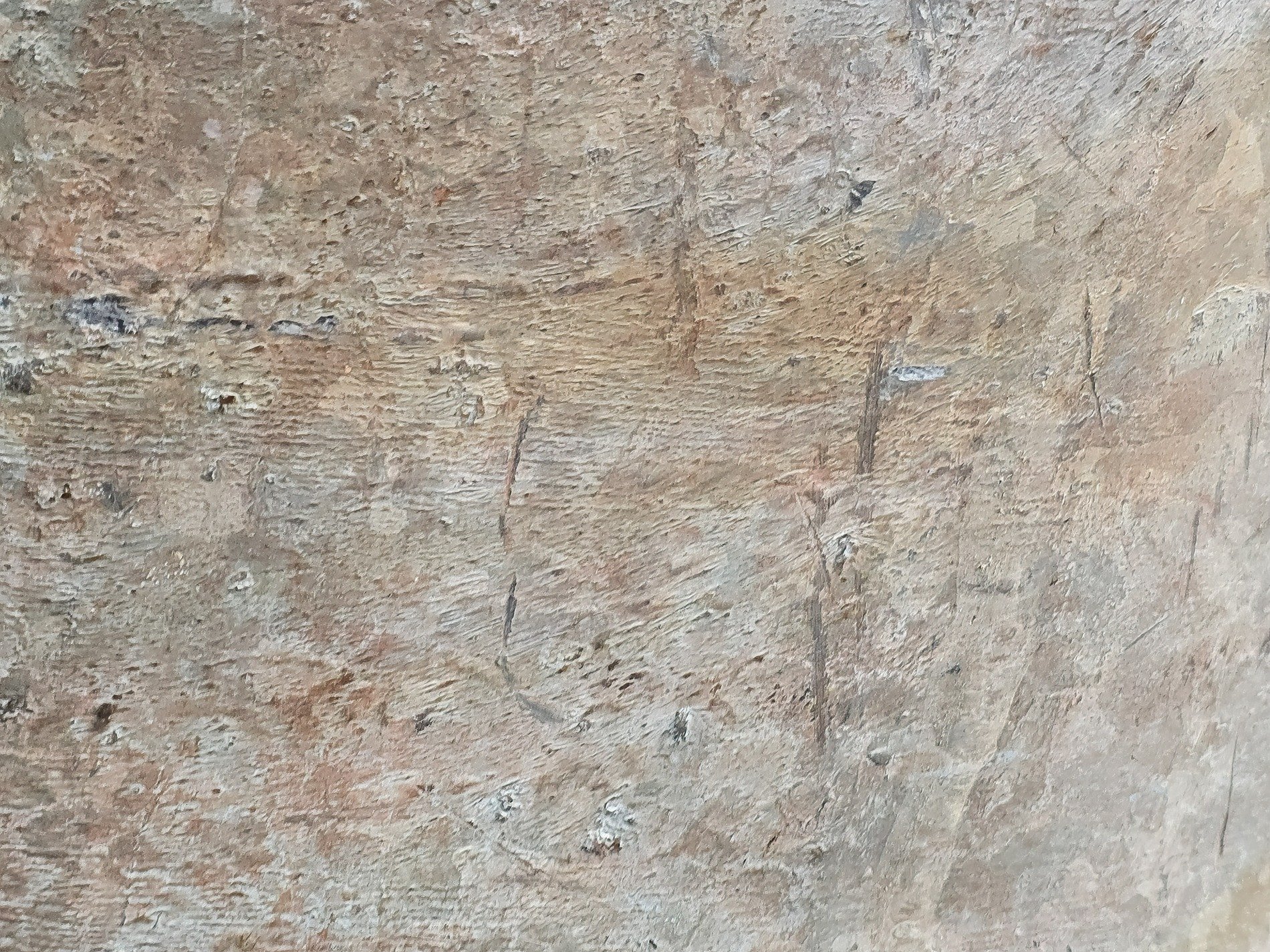 Rough stone holds the dust, scratches mark the silent face, earth tones fade away