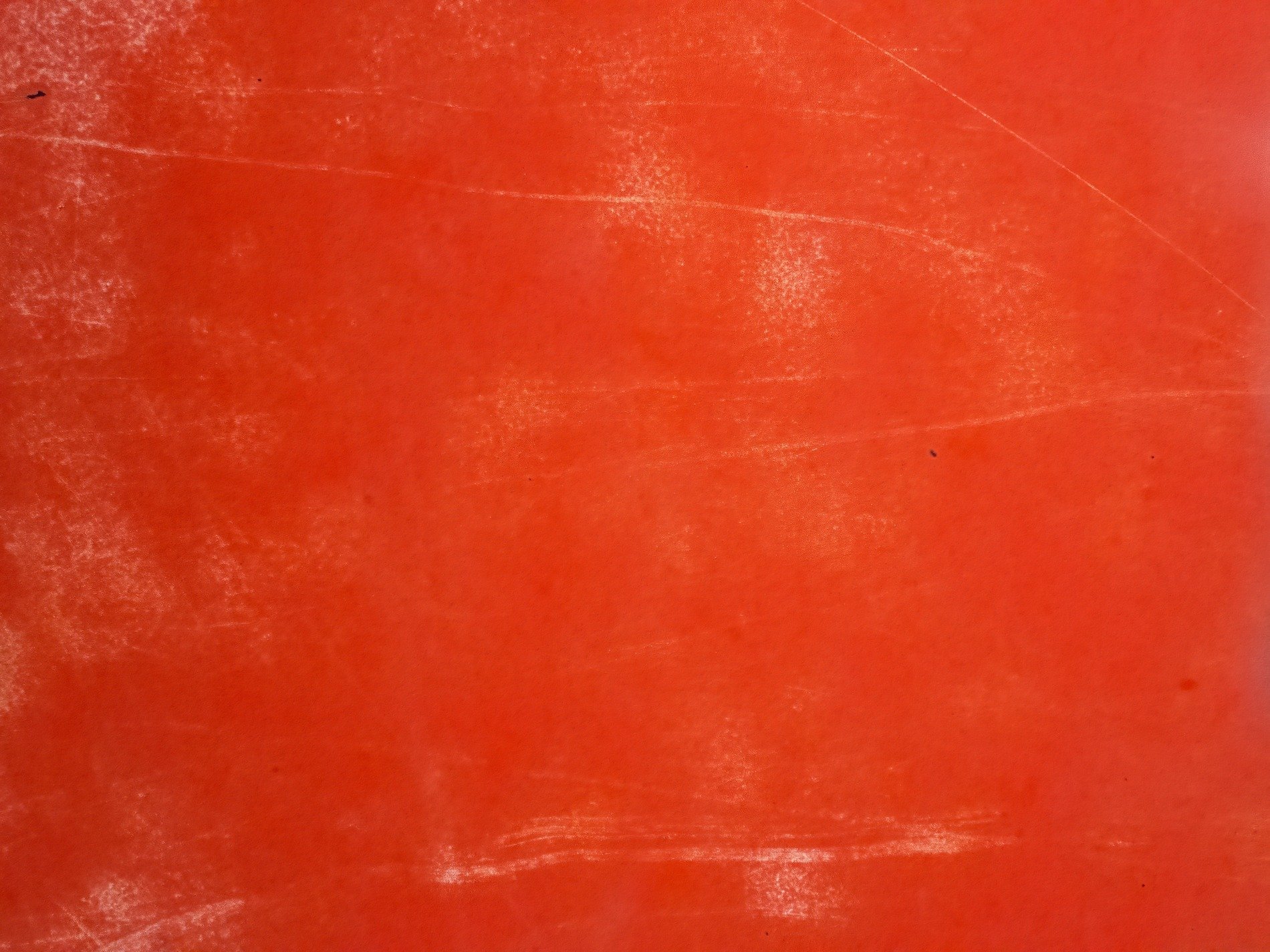 Searing orange field, white scuffs mar the vibrant glow, time leaves its light mark