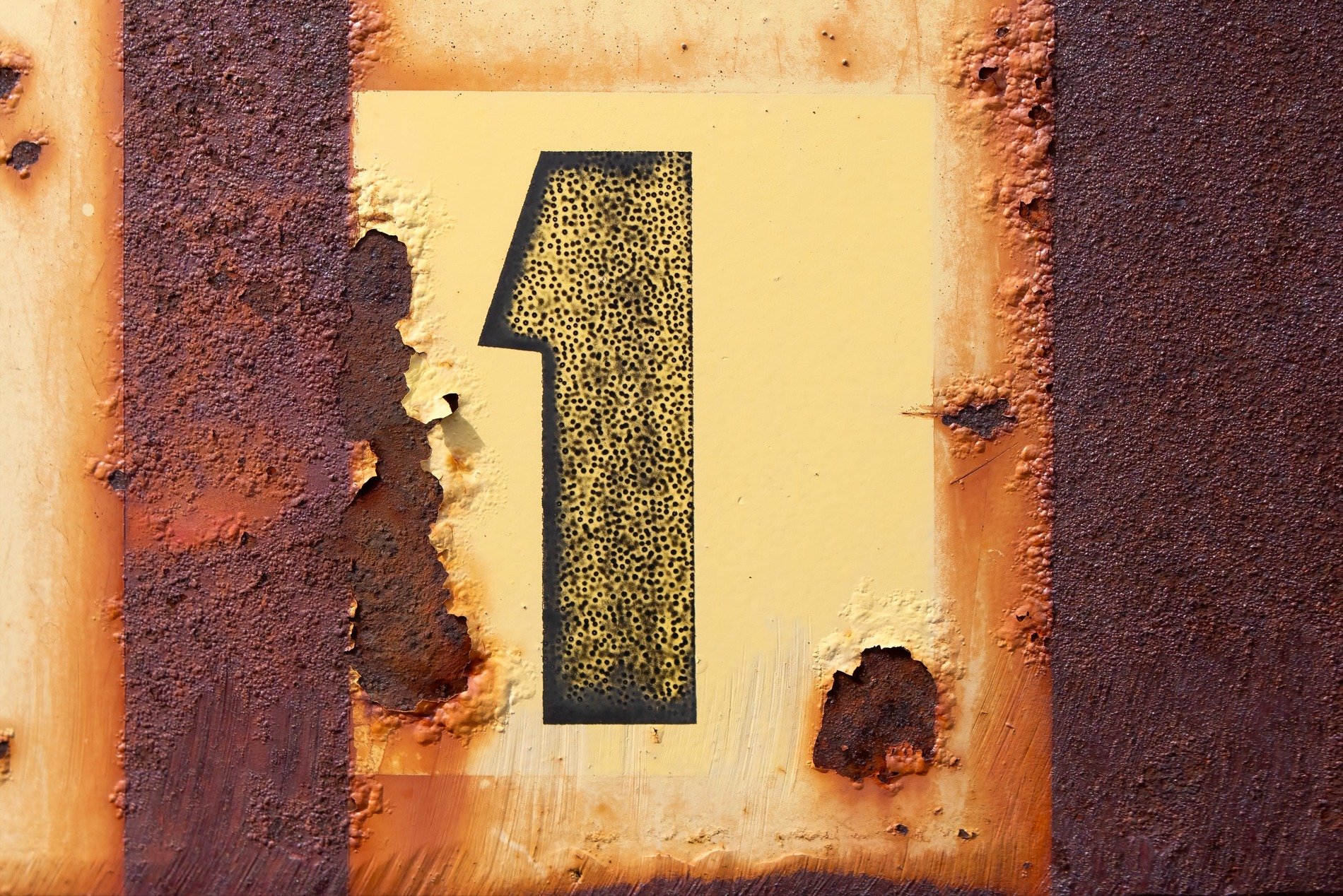 Stenciled number one, orange rust eats through the paint, metal yields to time