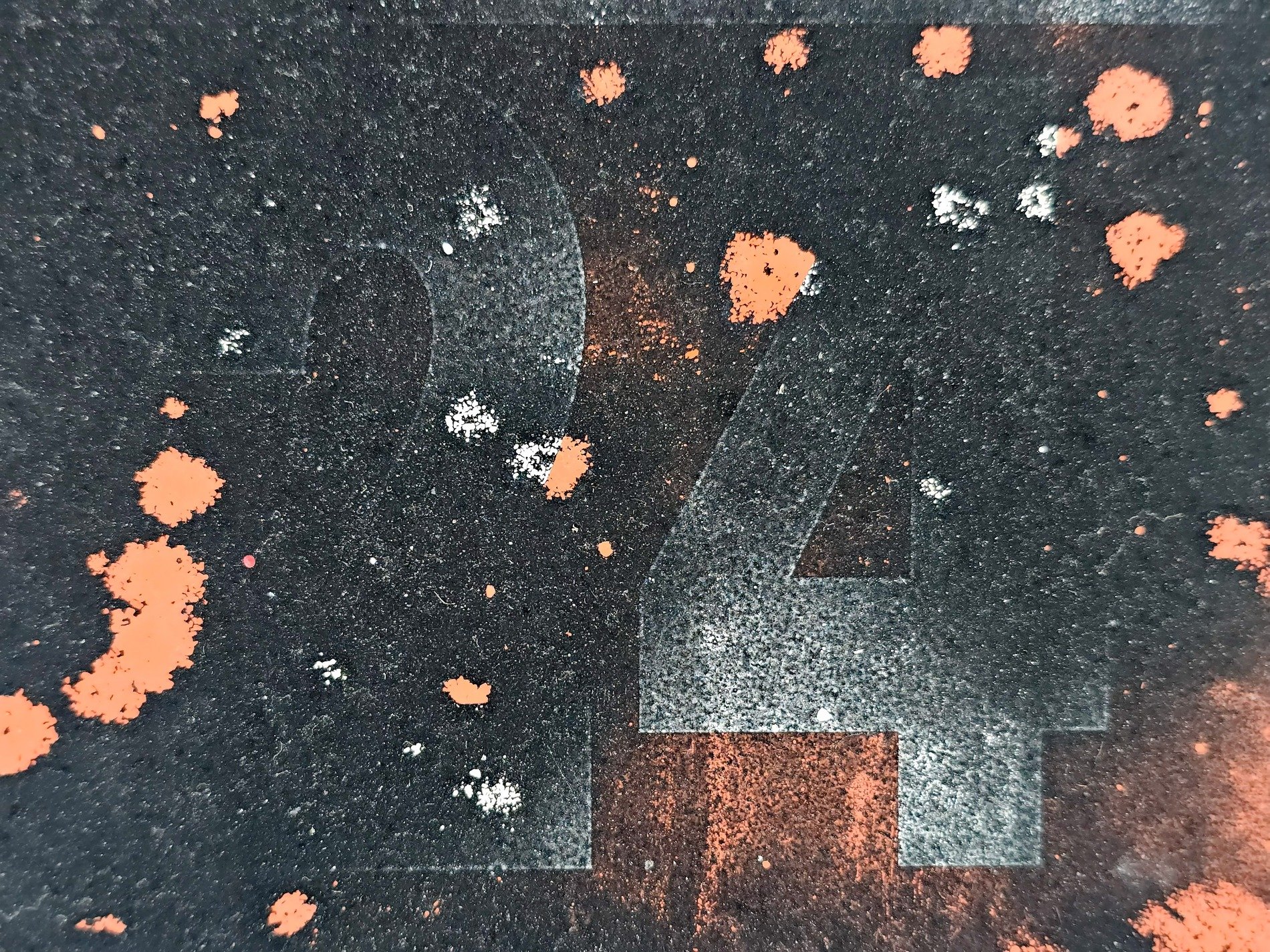 Stenciled numbers fade, orange splatter marks the dark, textured grit remains