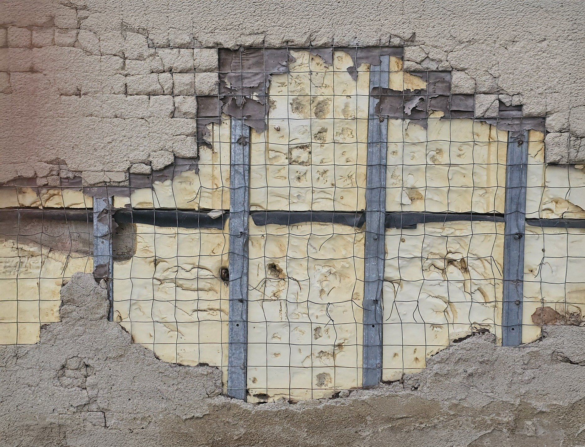 Stucco breaks away, wire mesh binds the inner core, hidden layers show