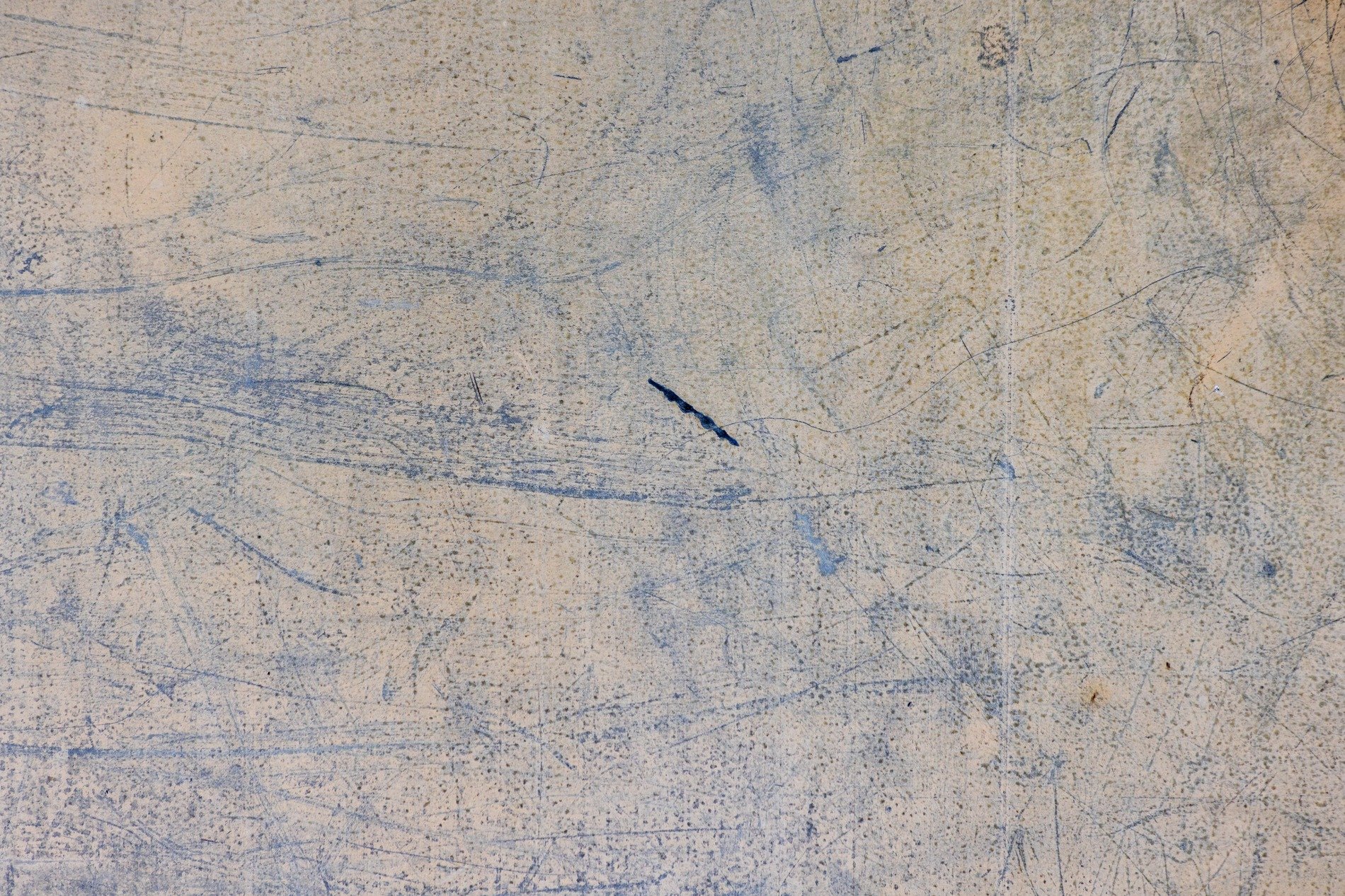 Tan skin has light marks, jagged scars trace the metal, grit marks the finish