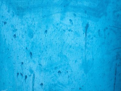 Azure paint remains, dark streaks trace a hidden path, weathered steel holds firm