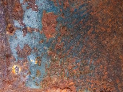 Blue fields meet the rust, orange grit claims the metal, years leave a deep trace