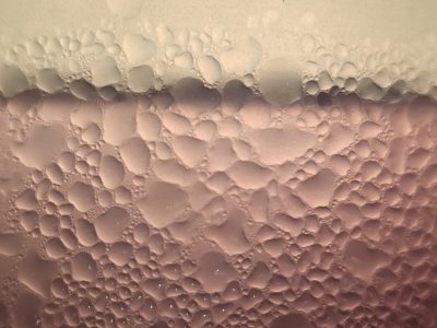 Blue frost meets the pane, crystalline paths trace the field, cold light holds the grit