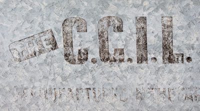 Zinc patterns shimmer, ink marks the weathered surface, iron holds its ground