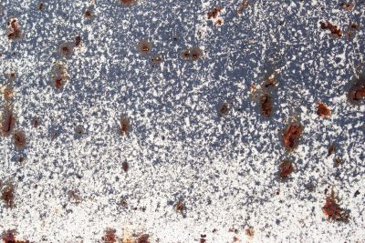 White paint flakes away, dark shadows hide deep within, rust pits cold hard steel