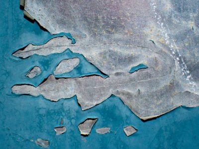 Blue skin flakes away, jagged edges meet the light, grit marks the finish