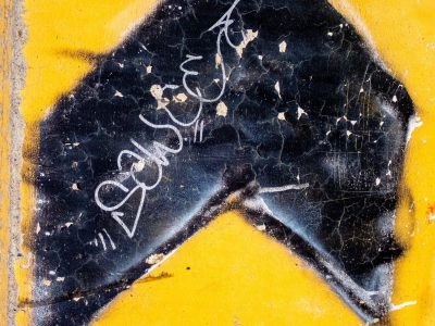 Blue skin has light marks, industrial paths trace the field, grit holds the finish