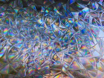 Clear shards hold the light, jagged lines trace the break, grit marks the sharp edge