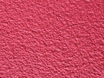 Crimson peaks arise, rough shadows dance on the wall, textured pink surface