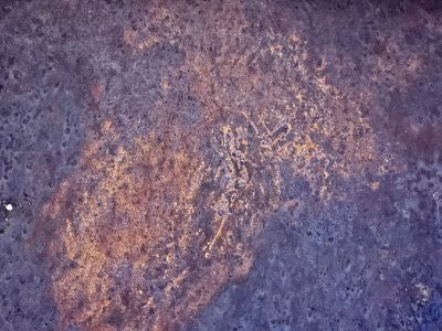 Dark fields meet the rust, orange mist holds the surface, grit claims the heavy