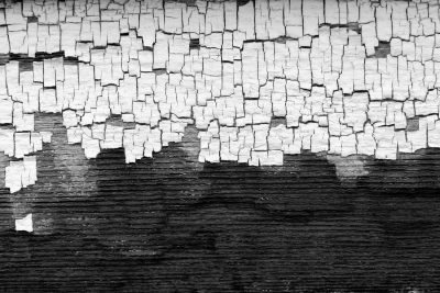 Dark grain holds the light, jagged scars scatter on top, grit marks the finish