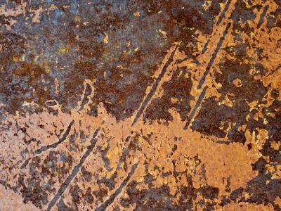 Dark grit flows so thick, jagged paths trace the metal, time leaves a deep mark