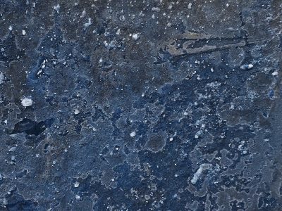 Deep blue grit and grime, white specks dot the weathered stone, cold texture endures