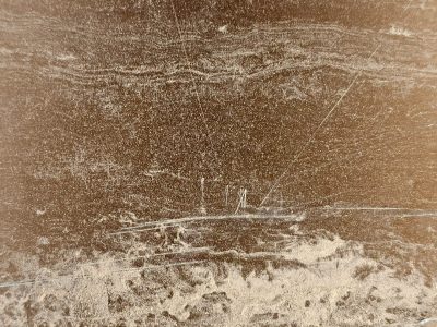 Dusty earth tones flow, sharp white lines cut through the grain, time wears down the stone