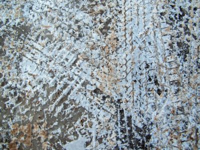 Frozen white and grey, patterns etched in dirty slush, winter's heavy path