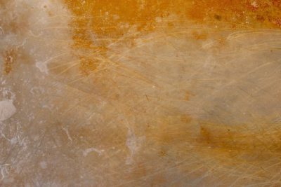 Gold mist holds the field, jagged scars trace the surface, light carves the metal