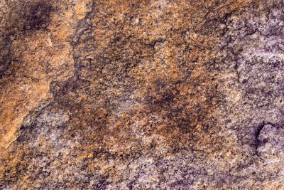 Grains of ancient sand, ochre stains the rugged earth, purple shadows creep