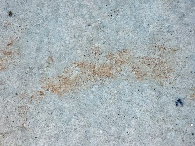 Gray slab holds its ground, rust drifts like a desert cloud, cold stone keeps the mark