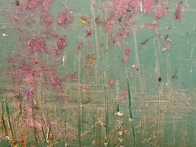 Green field worn by time, reddish scars mar the surface, deep scratches remain