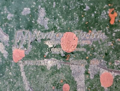 Green paint flakes away, ancient marks of industry, sixty years of wear