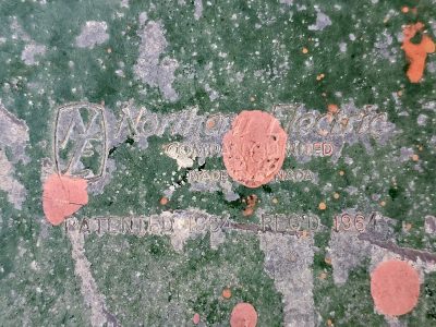 Green paint peels away, stamped letters from sixty-four, orange spots remain