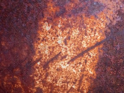 Grey grit binds the wall, faint blue wash ghosts the surface, rough stone holds the light