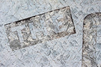 Grey patterns meet light, the script marks the metal skin, grit claims the heavy